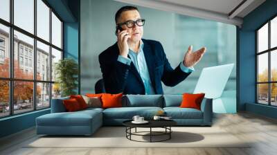 Portrait of a senior man smiling in suit with a phone and a laptop computer in office Wall mural